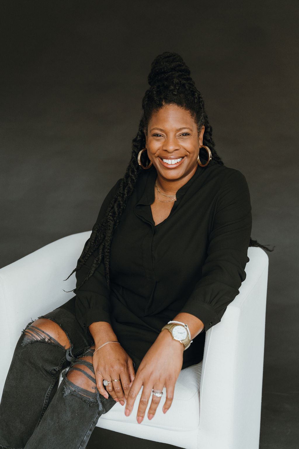 Pastor Portia Allen seated and smiling in a black blouse